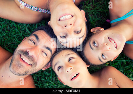 Passage portrait of a happy family lying on the grass Banque D'Images