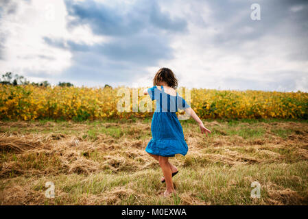 La filature de fille en face d'un champ de soya Banque D'Images