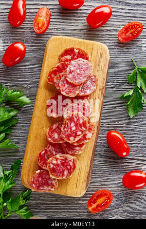 Tranches de salami avec des tomates sur des backgtound Banque D'Images