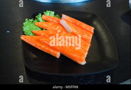 Les bâtonnets de crabe surimi sur la plaque noire. Studio Photo Banque D'Images