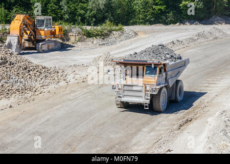 Et de l'excavateur Caterpillar dump truck roulant avec une charge de la marne à l'ENCI (première industrie du ciment néerlandais) Carrière de marne, Maastricht, Pays-Bas. Banque D'Images