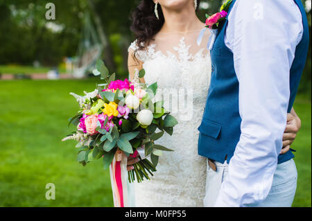 Rose, blanc, vert et bleu de mariée mariage détails en blanc robe de dentelle et nettoyer en gilet avec boutonnière fleur Banque D'Images