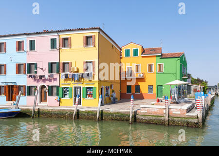 Le colorfil gaz ou carburant pompes sur l'île de Burano, Venise, Italie sur le bord de la lagoo avec lave-linge en train de sécher dehors Banque D'Images