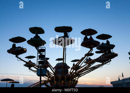 Les enfants et les parents à cheval sur une élévation merry-go-round carrousel ou au coucher du soleil sur la Riva dei Sette Martiri, Venise, Italie en hiver Banque D'Images