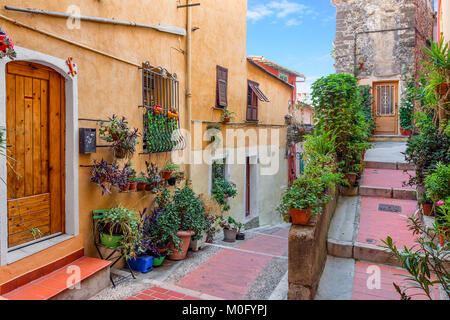 Rue étroite entre les maisons anciennes dans la partie historique de Menton - ville sur la côte d'Azur. Banque D'Images