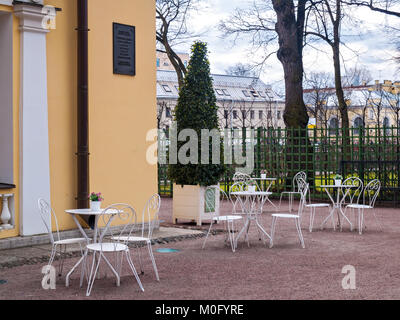 Cafe dans le parc en plein air au début du printemps en avril contre l'arrière-plan des bâtiments avec des chaises et ajouré blanc tableaux blancs avec un l Banque D'Images