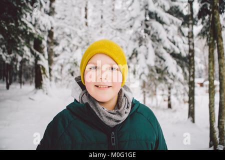 Les garçons souriant debout dans la forêt dans la neige à la recherche à l'appareil photo. Banque D'Images