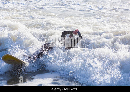 Tomber du surfeur surf board, exploitant les grandes vagues et mer agitée à Bournemouth, Dorset UK en Janvier Banque D'Images