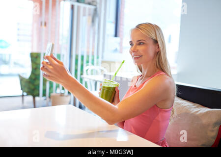 Femme avec le smartphone en tenant au restaurant selfies Banque D'Images