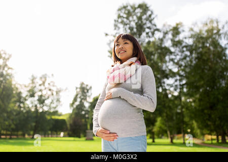 Happy pregnant asian woman at park Banque D'Images