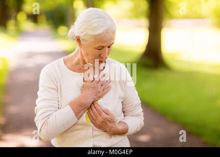 Woman sensation de malaise au parc d'été Banque D'Images