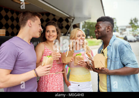 Happy friends avec boissons manger au camion alimentaire Banque D'Images