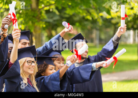 Les élèves heureux dans le mortier avec des diplômes Banque D'Images