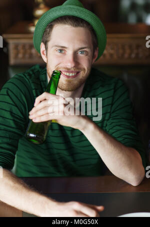 Man drinking beer du vert bouteille au bar ou au pub Banque D'Images