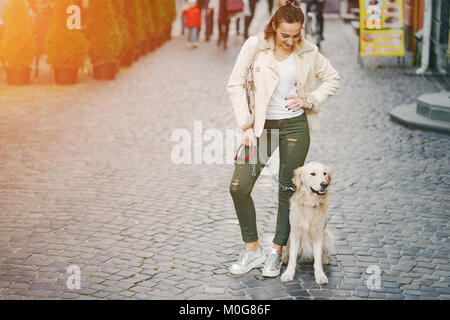 Girl walking dog in the city Banque D'Images