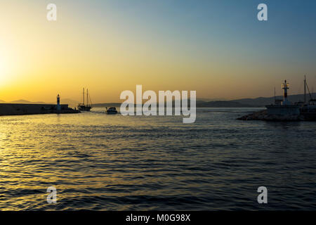 Les pêcheurs et voilier au coucher du soleil dans la marina d'Alimos à Athènes, Grèce. Banque D'Images