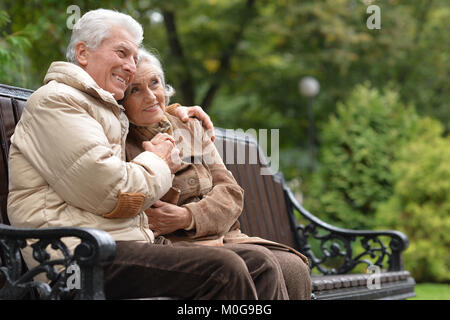 Couple assis sur le banc en bois Banque D'Images