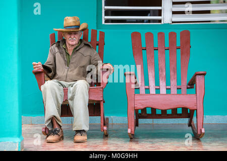 Homme seul dans un fauteuil à bascule sur le porche, Vallée de Vinales, Cuba Banque D'Images