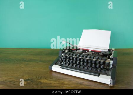 Machine à écrire Vintage sur un bureau en bois. Fond vert menthe. Banque D'Images