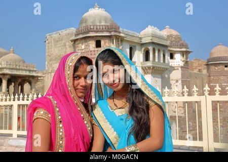 CHITTORGARH, Rajasthan, INDE : Portrait de deux belles jeunes femmes vêtues de saris colorés avec Ratan Singh Palace dans l'arrière-plan Banque D'Images