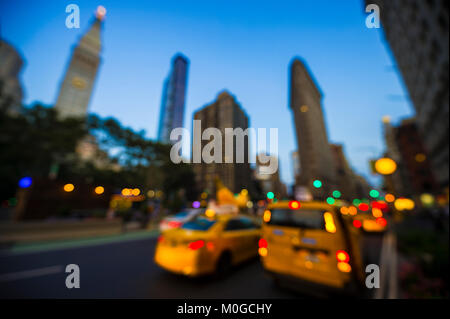 Résumé de la défocalisation des taxis jaunes de la conduite dans les rues de la ville à la tombée de la nuit à New York City, USA Banque D'Images