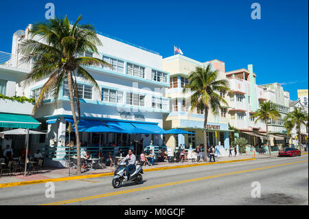 MIAMI - 29 décembre 2017 : Un scooter passe l'emblématique de l'architecture Art Déco de Ocean Drive sur un matin étonnamment désert. Banque D'Images