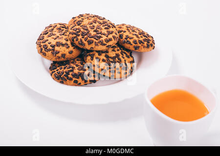 Tasse avec du jus de fruits et les cookies sur un tableau blanc Banque D'Images