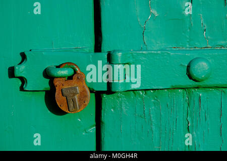 Ancien cadenas rouillé sur porte de garage peint en vert, Norfolk, Angleterre Banque D'Images