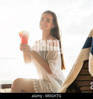 Portrait d'une belle jeune femme souriante tout en profitant d'un COC Banque D'Images