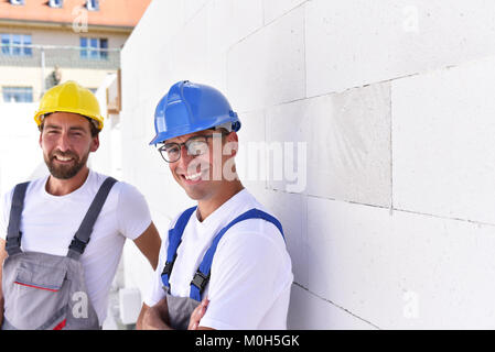 Le travail d'équipe sur le site de construction - maçon construire une maison familiale Banque D'Images