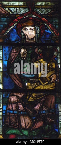 Un vitrail dans l'église Saint-Étienne, Brie-Comte-Robert, France, représentant des images religieuses et des œuvres artisanales caractéristiques de l'art ecclésiastique français et des traditions gothiques. Banque D'Images