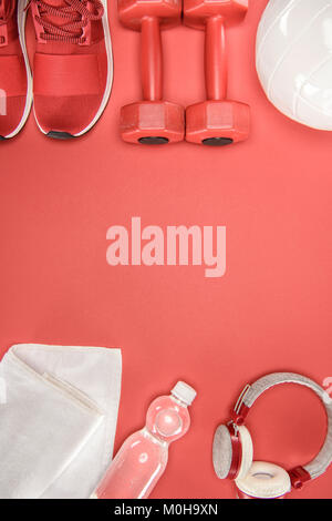 Appareils de sport avec des chaussures, des haltères, ballon et headphones isolated on red Banque D'Images