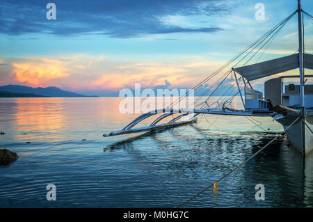 Banka, bateau de pêche traditionnelle des Philippines au coucher du soleil, l'île de Cebu, aux Philippines Banque D'Images