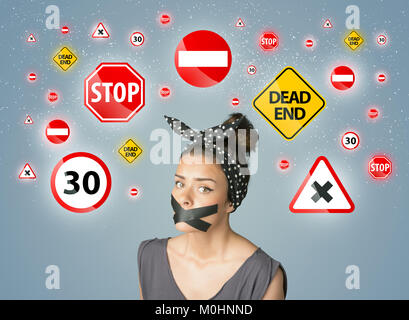 Jeune femme avec la bouche avec du ruban adhésif et les feux de circulation autour de la tête Banque D'Images