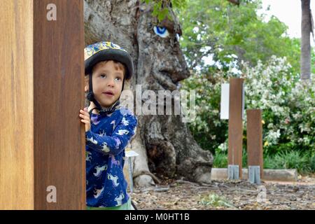 Jeune fille à l'écoute de Billy le bombax tree, Anderson Park Botanic Gardens, Townsville, Queensland, Australie Banque D'Images