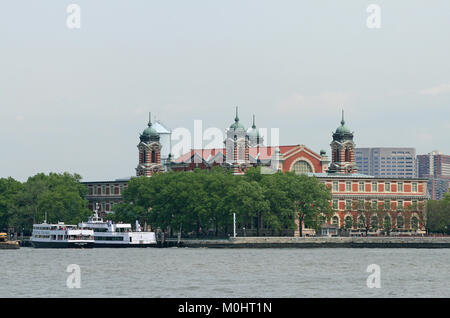 Ellis Island, l'entrée du bâtiment principal (qui abrite aujourd'hui le Musée de l'Immigration) et la Statue de la liberté les bateaux de croisière, Upper New York Bay, New York : Banque D'Images