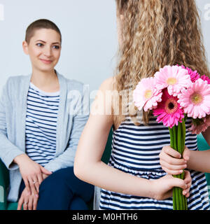 Happy Mother's Day, Journée de la femme ou d'anniversaire. Cute little girl offrir à maman bouquet de gerberas rose. Mère et fille concept. Banque D'Images