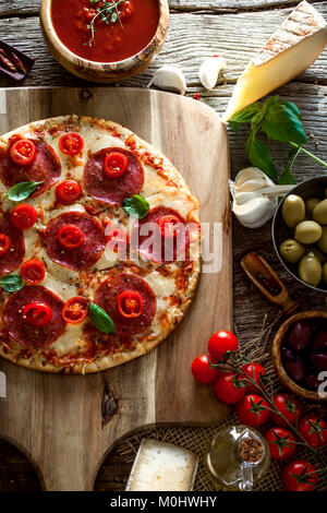 Pizza italien frais sur le bois. Pizza au fromage, salami et les tomates. Le fast food. Des pizzas Banque D'Images