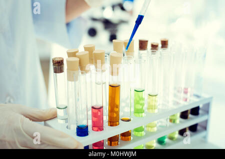 Close up of scientist pouring liquid into test tube Banque D'Images