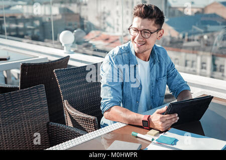 Jeune rêveuse freelancer pense à quelque chose et souriant Banque D'Images