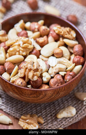 Y compris les mélanges de noix, noisettes, noix de cajou et amandes blanchies dans le bol en bois Banque D'Images