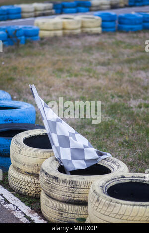 Pavillon de course, jaune et bleu sur le parquet de pneus race course. Banque D'Images