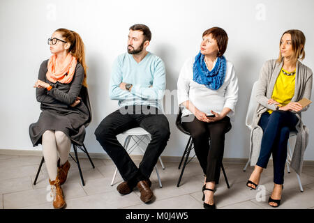 Les gens dans des emplois occasionnels assis dans une rangée Banque D'Images