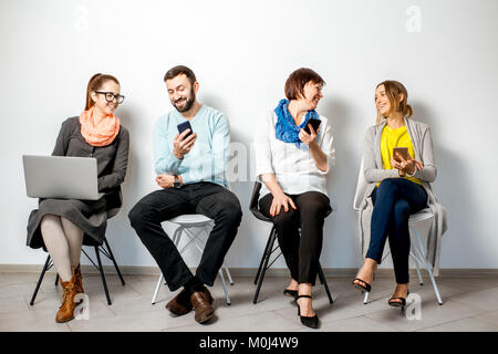 Les gens avec des gadgets sur le fond blanc Banque D'Images