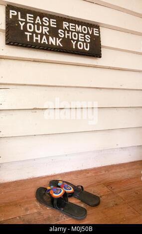 Signe sur le porche avant de demander à être retiré des chaussures Banque D'Images