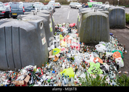 Verre plein et le débordement des bacs de recyclage dans le parc de voiture après Noël et Nouvel An Banque D'Images