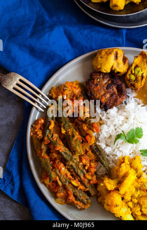 Repas indien avec Aloo Gobi, okra curry, riz et pakoras Banque D'Images