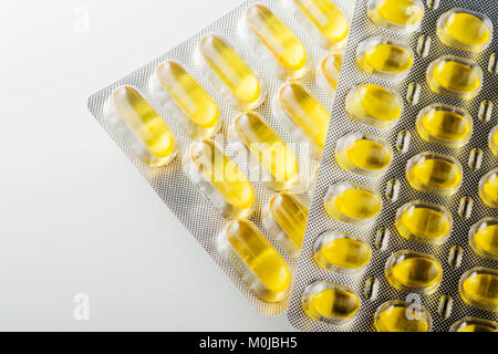 Capsules à base de plantes et des capsules d'huile de poisson dans des portions dans une boîte Banque D'Images