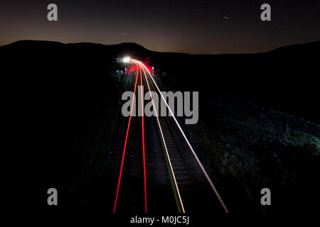 Northern Rail du passage des trains dans la nuit au nord de Blea Moor avec Ingleborough Ribblehead sur l'horizon Banque D'Images