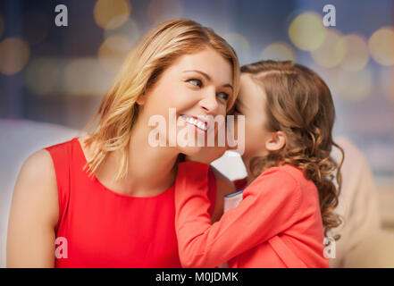 Mère et fille heureux chuchotant à l'oreille Banque D'Images